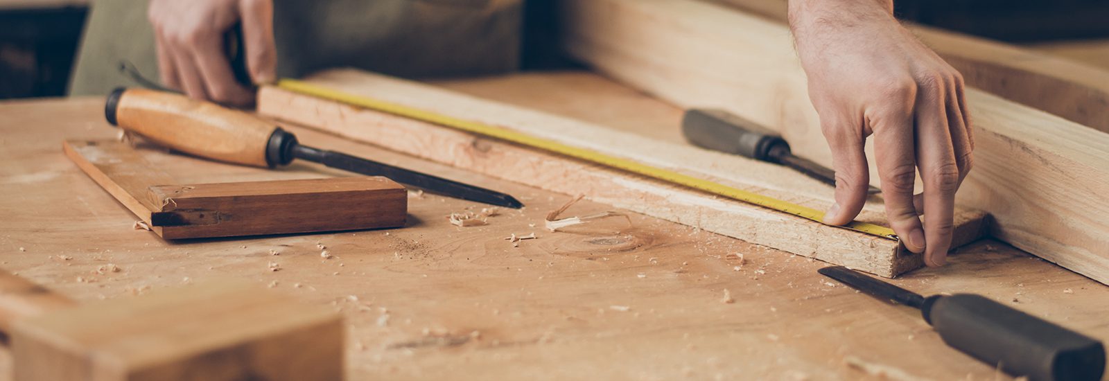 closeup photo of  cabinetmaker's tabletop.  Craftsman holding ru